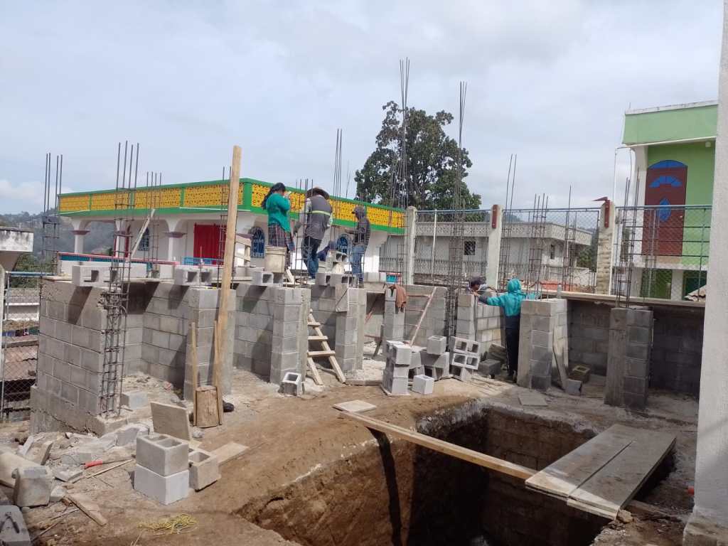 A group of people constructing the structure of the cubicles of a toilet system